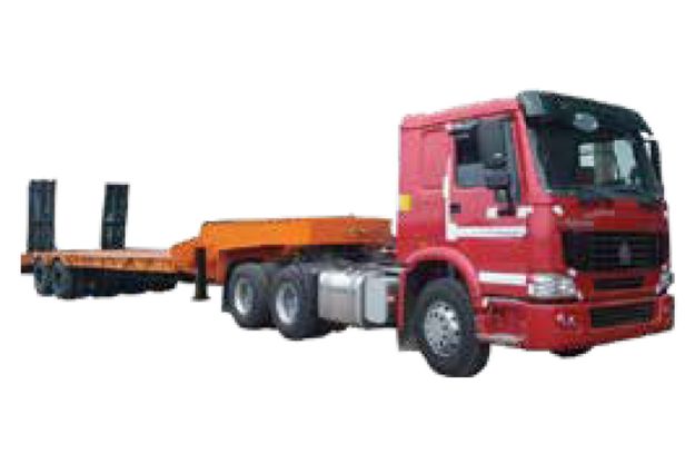 A large, deep red Super Awan Transport lowbed trailer with multiple axles and hydraulic ramps sits on a paved lot. A yellow excavator rests securely on the trailer bed.